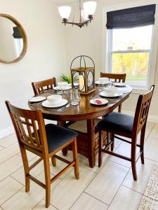 a dining room table with chairs and a mirror at The Gables of PEI in Stanley Bridge