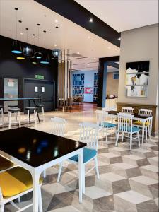 a dining room with tables and chairs in a building at Country Inn & Suites in Lucknow