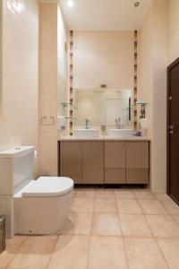 a bathroom with a toilet and two sinks and a mirror at Casa di Bakalovi in Burgas City