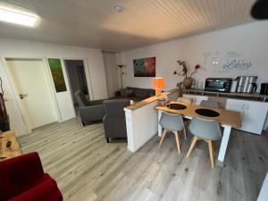 eine Küche und ein Wohnzimmer mit einem Tisch und Stühlen in der Unterkunft Strandnest Büsum Apartments in Büsum