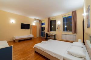 a bedroom with two beds and a desk and a television at Casa di Bakalovi in Burgas City