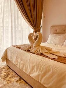 uma cama com dois cisnes de toalha sentados nela em Nilai Youth City Residence em Nilai