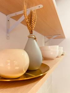 un vaso bianco su uno scaffale con piatti e ciotole di Nilai Youth City Residence a Nilai