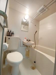 a white bathroom with a toilet and a sink at 《難波・心斎橋にアクセス最高！》宿泊2名 in Osaka