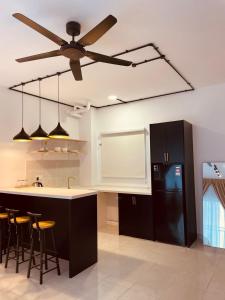 uma cozinha com uma ventoinha de tecto e um frigorífico preto em Nilai Youth City Residence em Nilai