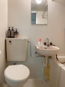 a white bathroom with a toilet and a sink at 《難波・心斎橋にアクセス最高！》宿泊2名 in Osaka