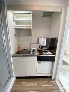 a small kitchen with white cabinets and a sink at 《難波・心斎橋にアクセス最高！》宿泊2名 in Osaka