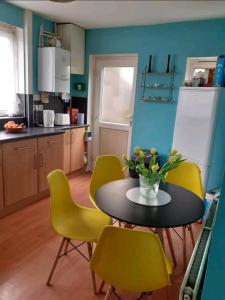 a kitchen with a table and yellow chairs at Welcoming Home Close to Transport Links in Thornton Heath