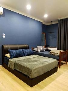 a bedroom with a bed and a blue wall at Spacious Home @ Kuching City Ctr in Kuching