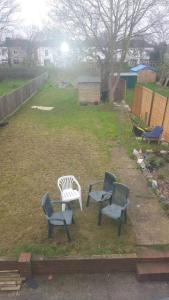 a group of three chairs sitting in a yard at Welcoming Home Close to Transport Links in Thornton Heath