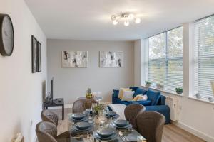 sala de estar con mesa y sofá azul en Cosy Retreat in the Heart of Golders Green, en Londres