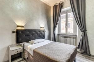 a bedroom with a bed with a black headboard and a window at Hotel Planet in Rome