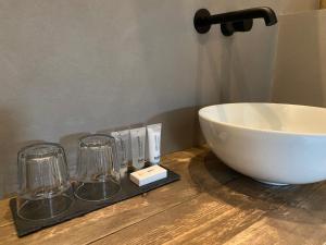 a counter with a bowl and two glasses on it at De Slaapsoof in Lier