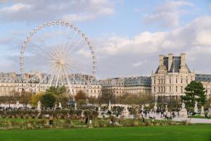 une roue ferris devant un grand bâtiment dans l'établissement Atala powered by Sonder, à Paris