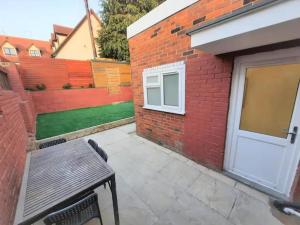 a patio with a bench and a brick building at 3-Bed House in Colchester with Parking and WiFi in Colchester