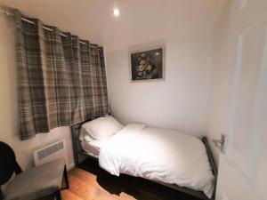 a small bedroom with two beds and a window at 3-Bed House in Colchester with Parking and WiFi in Colchester