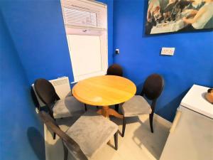 a table and chairs in a room with a blue wall at 3-Bed House in Colchester with Parking and WiFi in Colchester