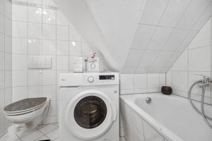 a bathroom with a washing machine and a toilet at Apartments am Hainich - 59m2, 4 Personen, Küche, Netflix, Parken, Hunde Willkommen, Nationalpark in Hörselberg-Hainich +27 photos