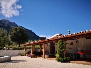 uma casa com um telhado com montanhas ao fundo em Villa Cusidore em Oliena