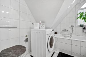 a white bathroom with a washing machine and a tub at Apartment am Hainich - 59m2, 4 Personen, Küche, Netflix, Parken, Hunde Willkommen in Hörselberg-Hainich