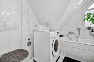 a white bathroom with a washing machine and a tub at Apartments am Hainich - 59m2, 4 Personen, Küche, Netflix, Parken, Hunde Willkommen, Nationalpark in Hörselberg-Hainich