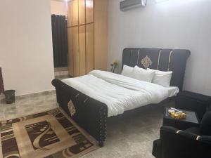 a bedroom with a large bed and a couch at Stay Inn Guest House in Islamabad
