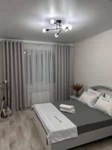 - une chambre avec un lit et un ventilateur de plafond dans l'établissement 2х комнатная квартира с кодовым замком, à Uralsk