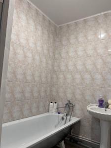 2х комнатная квартира с кодовым замком في أورالسك: حمام مع حوض استحمام ومغسلة