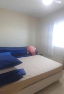 Ce lit se trouve dans un dortoir doté d'oreillers bleus. dans l'établissement Casa nova, piscina, área gourmet e muito conforto., à Iguaba Grande