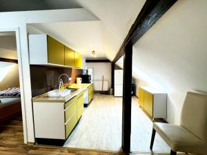 a kitchen with yellow and white cabinets in an attic at City Apartments in Hof in Hof