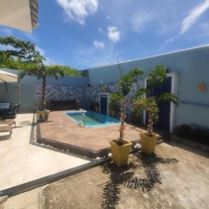 d'une terrasse avec une piscine ornée de plantes en pot et d'un bâtiment. dans l'établissement Casa nova, piscina, área gourmet e muito conforto., à Iguaba Grande