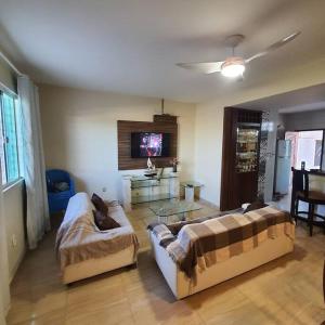 - un salon avec deux canapés et une télévision dans l'établissement Casa nova, piscina, área gourmet e muito conforto., à Iguaba Grande
