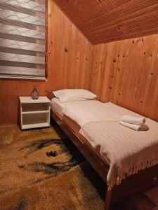 1 dormitorio con 1 cama en una habitación de madera en Planinska kuća Ruža en Kupres