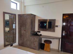 a bathroom with a sink and a tv on a wall at Hotel AK International - Chennai in Chennai
