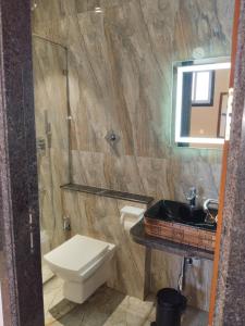 a bathroom with a toilet and a sink and a mirror at Hotel AK International - Chennai in Chennai
