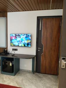a room with a door and a tv on the wall at Hotel AK International - Chennai in Chennai