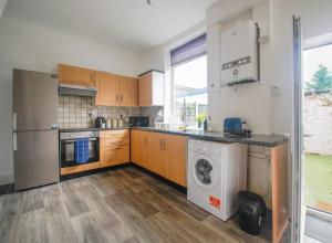 a kitchen with a washer and dryer at Comfy Bury house for contractors & families - Street parking 