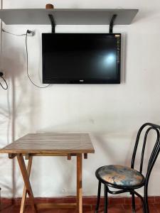 a tv hanging on a wall with a table and a chair at Monoambiente F en Ctes Cap in Corrientes