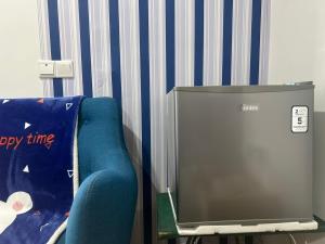 een televisie en een blauwe stoel in een kamer bij MySoho-Armadale,Gala City in Kuching