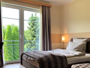 a bedroom with a bed and a large window at Das Landhaus ***S in Prüm