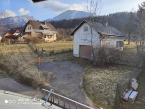 ein altes Haus auf einem Feld mit Bergen im Hintergrund in der Unterkunft Nice small house in beautiful Carinthia in Feistritz im Rosental