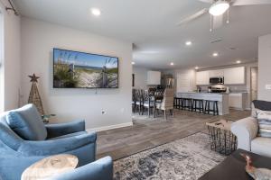uma sala de estar com mobiliário azul e uma cozinha em Bama Breeze em Foley