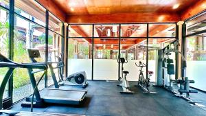 a gym with several treadmills and elliptical machines at Princess Kamala Beachfront Hotel - SHA Extra Plus in Kamala Beach