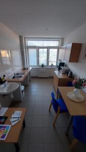 a room with a kitchen with a sink and tables at ŠD Urbánkova 2 in Košice