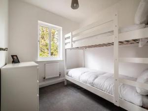 a bedroom with two bunk beds and a window at Pass the Keys Spacious modern home with parking in Exmouth in Exmouth