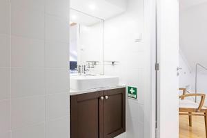ein Bad mit einem Waschbecken und einem Spiegel in der Unterkunft Gonzaga Suite by LovelyStay in Porto