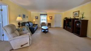 a living room with a couch and a table at LYONS DEN - 3 Bedroom Home home in Jekyll Island +14 photos