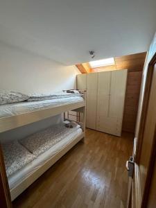 a bedroom with two bunk beds and a wooden floor at Suan Hut in Ziano di Fiemme