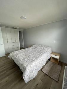 1 dormitorio con 1 cama y suelo de madera en Departamento a orillas del lago, en Llanquihue