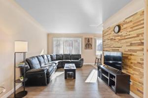 sala de estar con sofá de cuero y TV en Modern Cozy 1 Bedroom Apartment in Shelby Township en Shelby